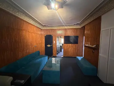 a living room with a blue couch and a television at Fes Apartment 2 in Fès