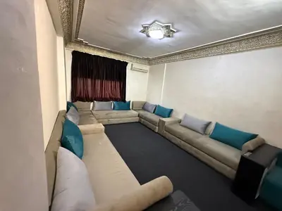 a living room with a large couch and blue pillows at Fes Apartment 2 in Fès