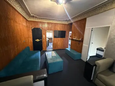 a living room with a blue couch and a tv at Fes Apartment 2 in Fès