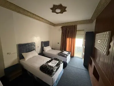 a hotel room with two beds and a window at Fes Apartment 2 in Fès