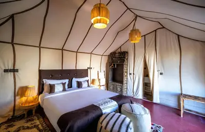 a bedroom with a large bed in a tent at Infinite Sky Luxury Camp Merzouga in Merzouga