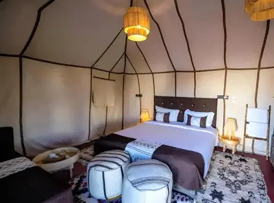 a bedroom with a large bed in a tent at Infinite Sky Luxury Camp Merzouga in Merzouga