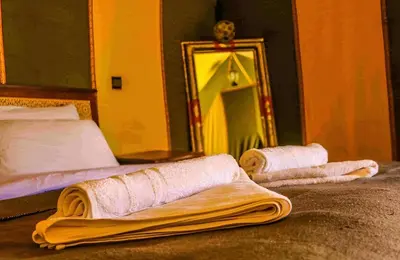 two towels on a bed in front of a mirror at Infinite Sky Luxury Camp Merzouga in Merzouga