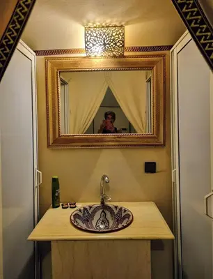 a man taking a picture of a sink in a bathroom at Infinite Sky Luxury Camp Merzouga in Merzouga
