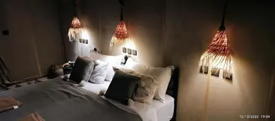 a bedroom with a bed with two lights on it at Infinite Sky Luxury Camp Merzouga in Merzouga