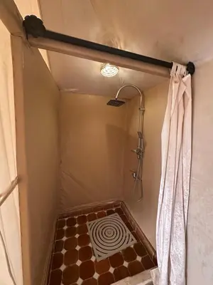 a bathroom with a shower with a shower curtain at Morocco Sahara Desert Camp in Merzouga