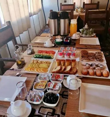 a table topped with lots of different types of pastries at Morocco Sahara Desert Camp in Merzouga