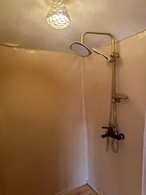 a bathroom with a shower with a light on the wall at Morocco Sahara Desert Camp in Merzouga