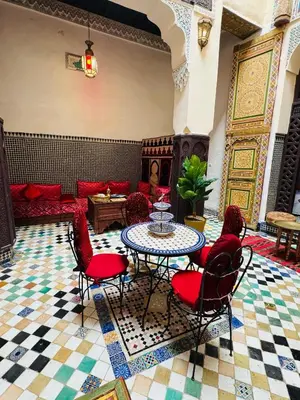 a living room with a table and chairs and a couch at PanoramicFES Riad in Fès