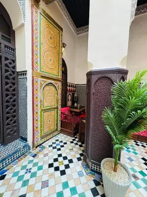 a living room with a tile floor and a door with a plant at PanoramicFES Riad in Fès