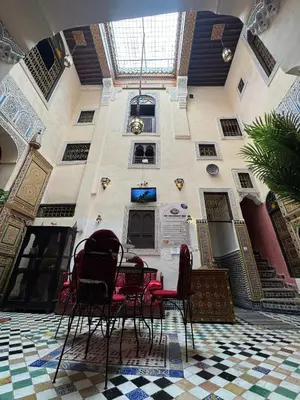 a room with chairs and a table in a building at PanoramicFES Riad in Fès