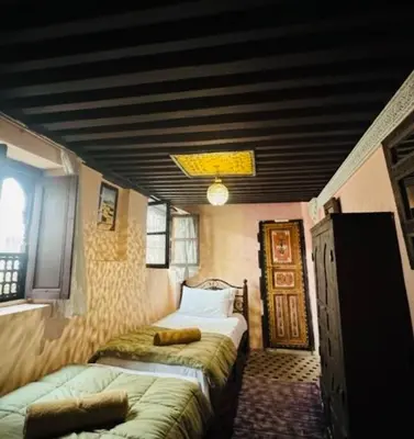 a bedroom with two beds in a room with a ceiling at PanoramicFES Riad in Fès
