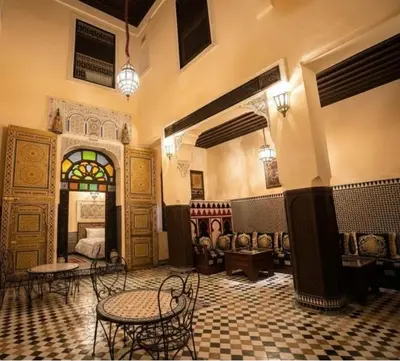 a room with chairs and a bed and a table at PanoramicFES Riad in Fès