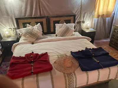 a bedroom with a bed with two bags on it at luxury camp Oasis Opal in Merzouga