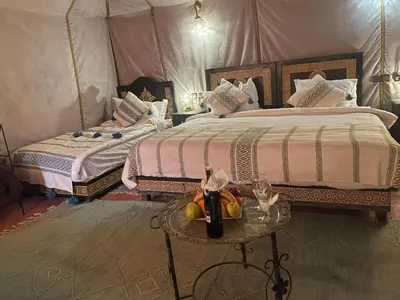 a bedroom with two beds and a table with fruit on it at luxury camp Oasis Opal in Merzouga