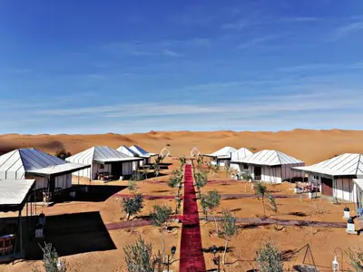 a red road in the middle of the desert at luxury camp Oasis Opal in Merzouga