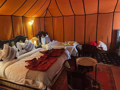 a bedroom with a bed in a tent at luxury camp Oasis Opal in Merzouga