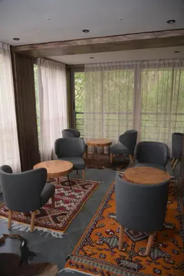 a waiting room with tables and chairs and windows at La Perle de Setti Fadma in Ourika
