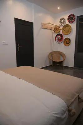 a bedroom with a bed and a table and plates on the wall at La Perle de Setti Fadma in Ourika