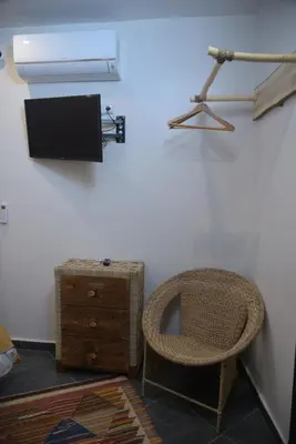 a room with a chair and a tv on a wall at La Perle de Setti Fadma in Ourika
