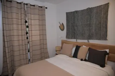 a bedroom with a bed and two curtains and a bed sidx sidx sidx at La Perle de Setti Fadma in Ourika