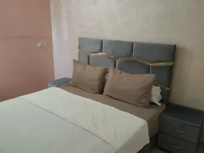 a bedroom with a bed with a headboard and pillows at jardaine d'Ifrane in Ifrane