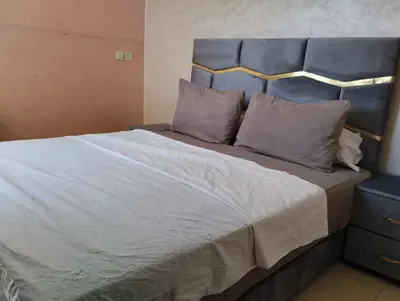 a bedroom with a large bed with a blue headboard at jardaine d'Ifrane in Ifrane