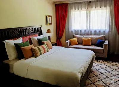 a bedroom with a large bed and a couch at Superbe appartement duplex à l'hivernage in Oulad Akkou