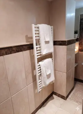 a bathroom with white towels on a towel rack at Superbe appartement duplex à l'hivernage in Oulad Akkou