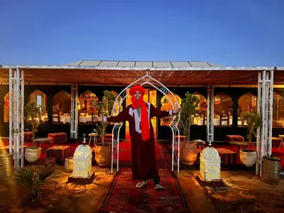 a man dressed as a clown standing under an arch at Luxury Stars Camp in Merzouga