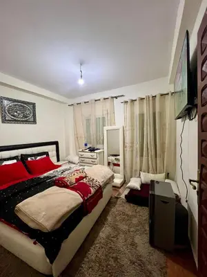 a bedroom with a large bed with red pillows at Maison confortable à Ifrane À louer in Ifrane