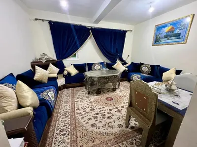 a living room with a blue couch and a table at Maison confortable à Ifrane À louer in Ifrane