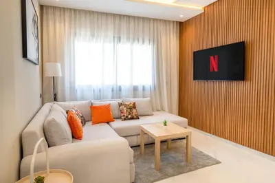 a living room with a couch and a table at Chic Beachfront Studio Appartment in Oulad Akkou
