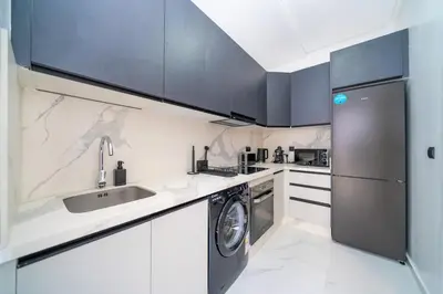 a kitchen with a sink and a washing machine at Chic Beachfront Studio Appartment in Oulad Akkou