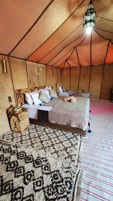 a bedroom with a bed in a tent at sahara desert camp in Merzouga