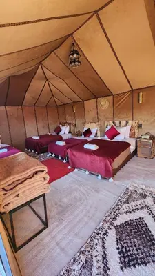 a room with two beds in a tent at sahara desert camp in Merzouga