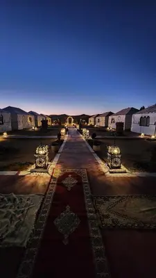 a group of tents in a desert at night at sahara desert camp in Merzouga