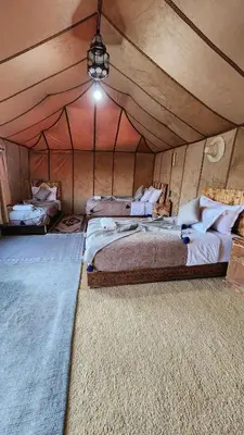 a bedroom with two beds in a tent at sahara desert camp in Merzouga