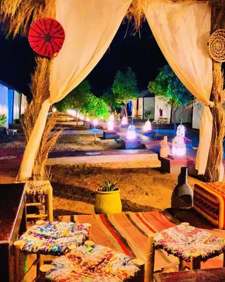 a group of chairs sitting under a tent at night at sahara desert camp in Merzouga