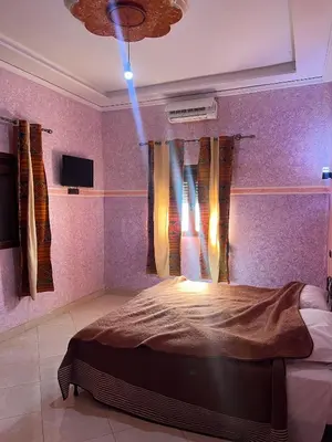 a bedroom with a bed with a blue light in it at Merzouga Roms in Merzouga