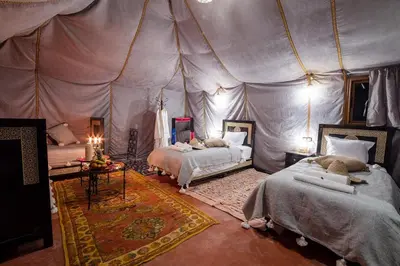 a bedroom with two beds in a tent at Merzouga Dream Camp in Merzouga