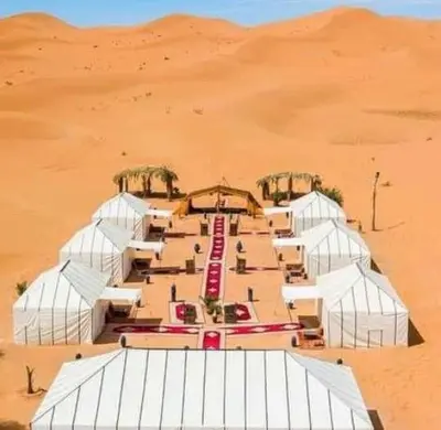 a group of white structures in the desert at beststaysbylocal in Merzouga
