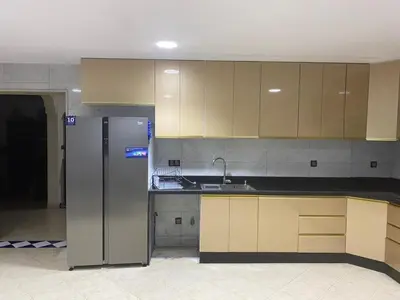a kitchen with a stainless steel refrigerator and cabinets at Étage dans une villa avec piscine partagée Meknès in Meknès