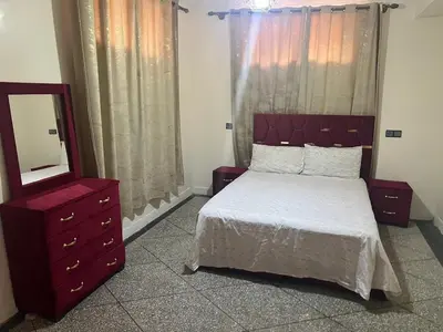 a bedroom with a bed and a dresser and a mirror at Étage dans une villa avec piscine partagée Meknès in Meknès