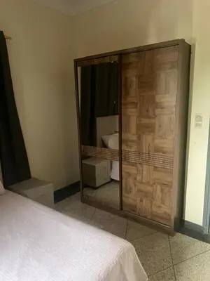 a bedroom with a large wooden cabinet with a mirror at Étage dans une villa avec piscine partagée Meknès in Meknès