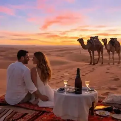 a couple sitting at a table in front of a camel caravan at Best Merzouga traductional camp in Merzouga