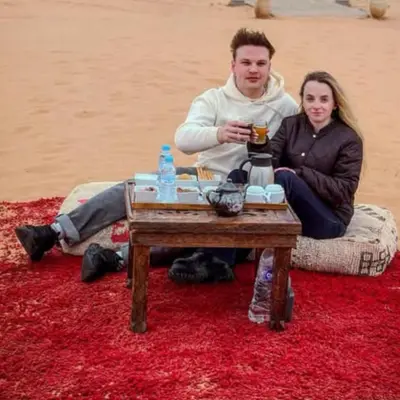 a man and a woman sitting around a table at Best Merzouga traductional camp in Merzouga