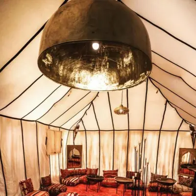 a large room with couches and a large ceiling at Best Merzouga traductional camp in Merzouga