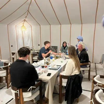 a group of people sitting around a table in a tent at Best Merzouga traductional camp in Merzouga