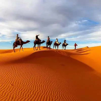 a group of people riding horses in the desert at Best Merzouga traductional camp in Merzouga